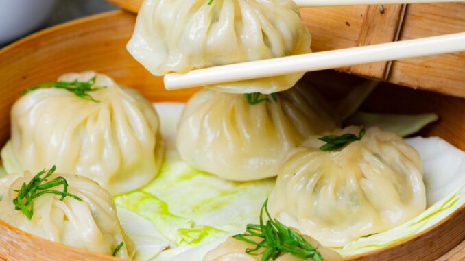 Delicious Steamed Momos with Dipping Sauce Steamed momos filled with meat and vegetables, served with spicy dipping sauce.